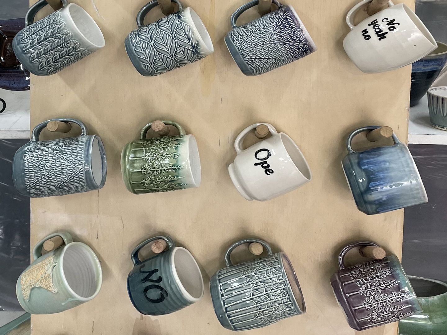 A wall display of handmade ceramic mugs from Pickwick Pottery.