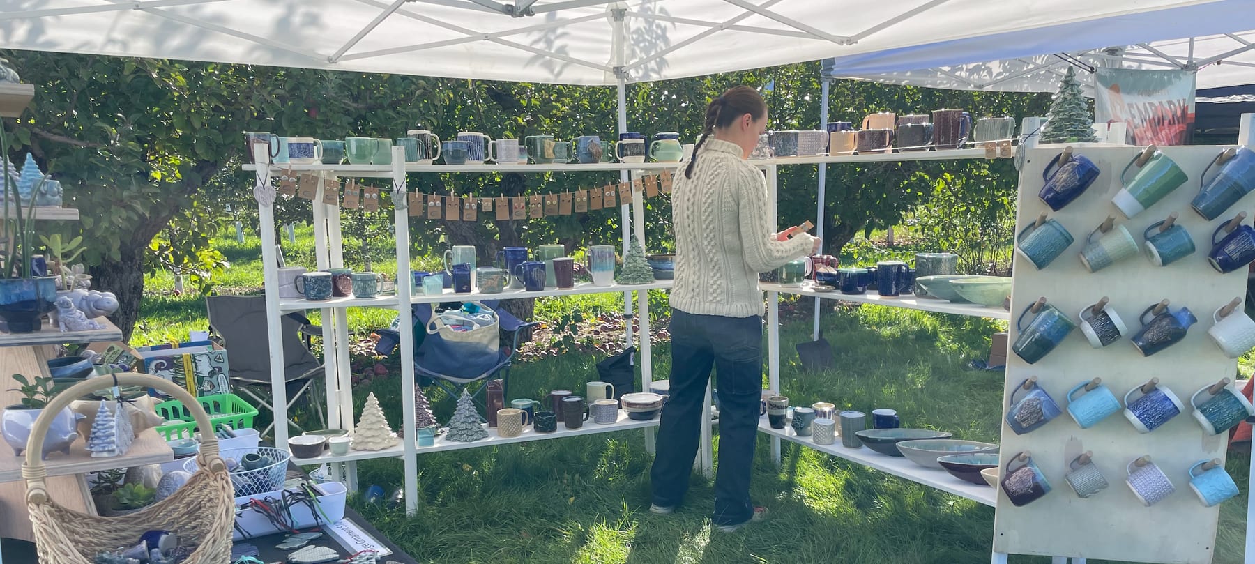 Pickwick Pottery market booth with handmade ceramics displayed outdoors.